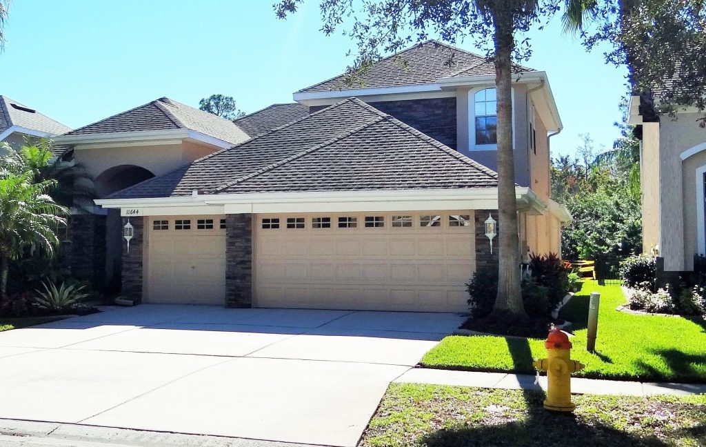 A residential home featuring a garage and a paved driveway leading to the entrance.