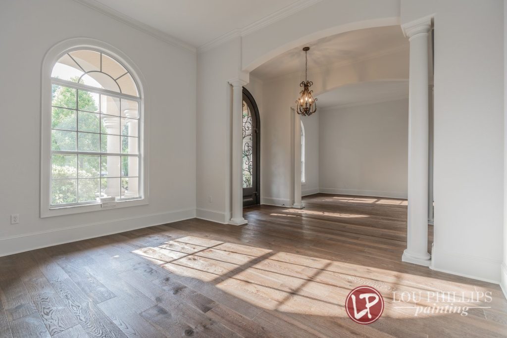 A spacious room featuring arched windows and polished hardwood floors, creating an elegant and inviting atmosphere.